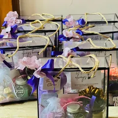 I love creating these bridesmaid proposal hampers for the 'Team Bride'. These modern, transparent boxes are filled with personalized goodies like scented candles, cookies, and custom notes to make your friends feel cherished.