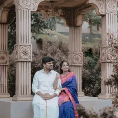 A serene moment captured at one of our heritage-themed sets. The couple's traditional outfits look stunning against the intricately carved stone gazebo.