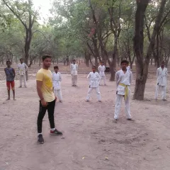 An instructor leads a class in an outdoor park. Training on uneven ground improves balance and strengthens stabilizing muscles.