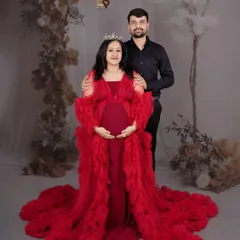 We believe every mother is a queen, and this portrait session is designed to celebrate that. Dressed in a magnificent red gown against a floral backdrop, this mom-to-be radiates strength and beauty, creating a regal and unforgettable maternity portrait.