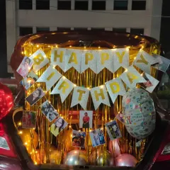 A surprise that's personal and full of memories. This car trunk decoration for a birthday includes a shimmering backdrop, fairy lights, and a banner of personal photos, showing how I can tailor any surprise to your story.