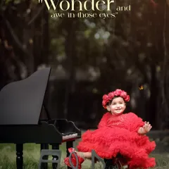 Dressed in a vibrant red dress, a little girl plays with a miniature piano in a beautiful green field. The image is full of life, color, and the wonder of a child's imagination.