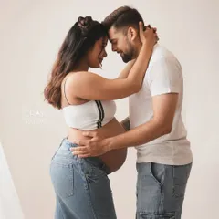 Foreheads together, sharing a quiet moment. This intimate pose is beautiful for capturing the deep connection between a couple before their baby arrives.