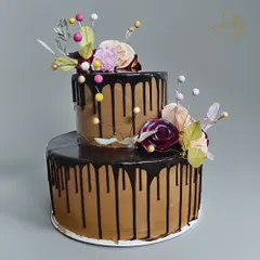An elegant two-tier chocolate drip cake, adorned with delicate wafer paper flowers. This sophisticated design is perfect for anniversaries, bridal showers, or milestone birthdays.