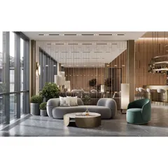 A sophisticated lounge area with curved sofas and floor-to-ceiling windows. The metallic accents, plush fabrics, and curated plant decor create a high-end, hotel-like ambiance.