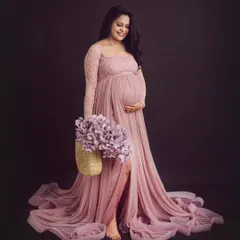 The definition of elegance. This mom-to-be looks radiant in our pink lace gown, with the long train spread out beautifully around her.