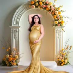 A glamorous solo maternity portrait featuring a stunning mom-to-be in a golden gown. The elegant floral arch and studio lighting highlight the beauty and glow of pregnancy.