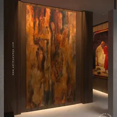 The 'Teros' downlight provides a seamless wall wash effect, grazing this textured art panel with light from below. This technique adds depth and drama, highlighting the material's rich colors and texture.