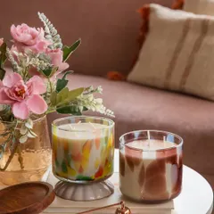 My artistic candles are designed to be a beautiful part of your home decor. Here, two of my multi-colored glass jar candles create a cheerful and inviting atmosphere, proving that an inviting space can be an affordable indulgence.
