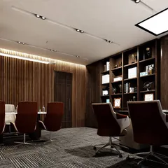 The conference area of the office, featuring a large meeting table and ergonomic chairs. The wood-slat wall and modern track lighting create a focused and professional setting for important discussions.