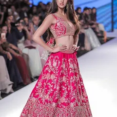 A vibrant pink lehenga with detailed floral embroidery, perfect for a sangeet or wedding reception. We can replicate your favorite designer styles with high-quality fabrics and craftsmanship.