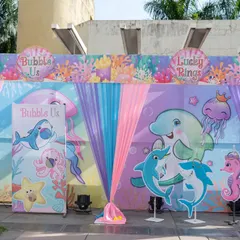The game and activity area for the underwater-themed party. The backdrop features cute cartoon sea creatures like dolphins, sharks, and jellyfish, creating a fun and engaging space for kids.
