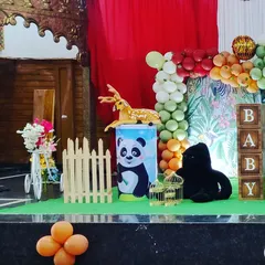 A glimpse of a jungle-themed party setup. I have various animal props like deer, pandas, and gorillas, along with a mini white picket fence to create a cute safari scene.
