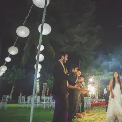 A beautiful night shot of the bride's entrance at her reception, with guests holding diyas or candles to welcome her.