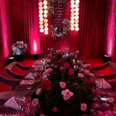 A full view of our Japanese-themed dining setup. The room is enveloped in red, with a moss and rose table runner leading the eye to a custom light installation, creating a scene of intense drama and romance.