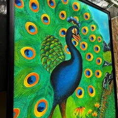 A close-up, angled shot of the framed peacock painting, showing the texture and detail of each feather.