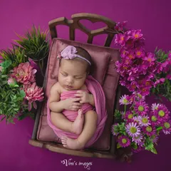 This overhead view shows the full composition of the floral bed theme, with the baby perfectly swaddled and positioned to look like she's floating in a garden.