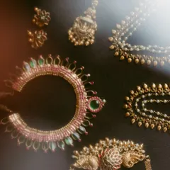 An artistic flat-lay of the bride's traditional temple jewelry. We use soft light to highlight the beautiful craftsmanship of each piece.