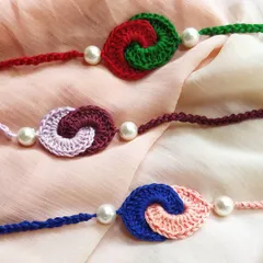 A collection of our 'pyaar ka bandhan' rakhis, featuring two intertwined crochet spirals in complementary colors. These designs symbolize the connected and loving relationship between siblings.