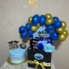 A grand gesture for Father's Day. This hamper includes a "Best Dad" themed cake and a large gift box filled with chocolates and flowers, topped with a blue and gold balloon arch.