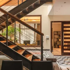 This staircase is more than just a way to get from one floor to another; it's a central architectural feature. The design integrates steel, wood, and cable railings, creating a light, transparent structure that connects the living spaces.