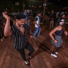 Leading a salsa workshop line dance during the Halloween party. Even with spooky makeup on, the focus is on fun, rhythm, and learning together.