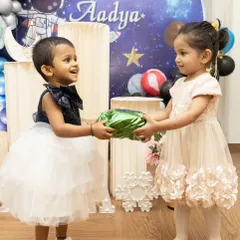 The joy of giving and receiving. This photo captures a lovely interaction between two young guests at a child's birthday party.