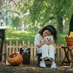A sweet and tender moment as a young girl hugs her stuffed owl in a peaceful garden setting. We love capturing these quiet, candid interactions during our outdoor sessions.
