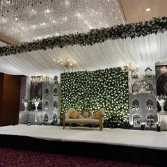 The magnificent stage for a Nikaah or reception at Crowne Plaza. The design features a massive floral border, white draped ceiling, and an elegant backdrop with a flower wall.