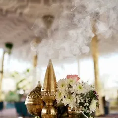 A centerpiece designed to cleanse the energy and invite positivity. The fragrant smoke from the incense cone rises from a traditional brass vessel, setting a spiritual and calming tone for the Bhajan Sandhya.