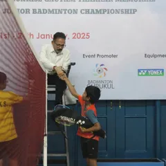 A moment of sportsmanship as a young player shakes hands with the umpire. We emphasize respect and fair play as core values in all the junior badminton tournaments we organize.