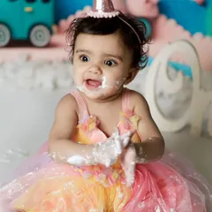 The moment of pure joy and a little bit of mischief. Getting messy with cake is the best part of a first birthday shoot.