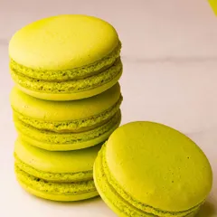 Vibrant pistachio-green macarons, stacked and ready to be enjoyed. I use high-quality ingredients to achieve these bright colours and authentic flavours.
