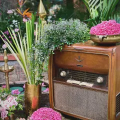 We love incorporating unique, personal touches like this vintage radio, adorned with fresh flowers. Antique props can add a wonderful sense of nostalgia and character to a wedding's decor, telling a story that is unique to the couple.
