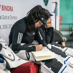 The mental game is just as important as the physical one. An athlete reviews her notes, analyzing her performance and strategizing for her next shots.