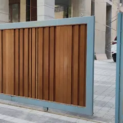 A sliding main gate featuring thick, vertical wooden planks within a sturdy metal frame. This design offers complete privacy and a robust, modern look.