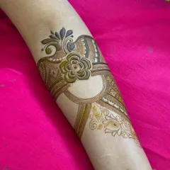 This arm band features a central flower with paisley elements, creating a symmetrical and jewelry-like effect.