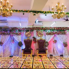 An elegant stage decoration perfect for an engagement or wedding reception at our Badlapur banquet hall. The setup features grand 'king and queen' chairs, a beautiful floral backdrop with sheer curtains and mood lighting, and an LED floor to create a royal ambiance.