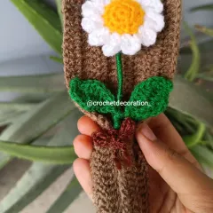 A close-up of a mini daisy bouquet, showing the single flower wrapped in brown yarn. It's a simple, rustic, and heartfelt little gift.