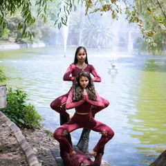 A three-person acro yoga pose that showcases teamwork and stability. We often create these human structures in our outdoor sessions, celebrating our collective strength.
