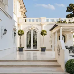 This all-white classical home in Ahmednagar was designed to be a space for making memories. The arched doorway adds a touch of elegance, while the sit-out porch perfectly frames the expansive garden, creating a home where every corner has a story.