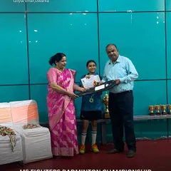 A young winner receives her certificate and medal at the MS Fighters Badminton Championship. It's moments like these that inspire the next generation of players to keep pushing their limits.