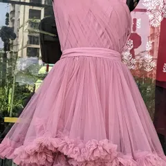 This cute pink frock with a ruffled, layered skirt is a lovely choice for a party. It's not too long, making it easy for little ones to run around and play.