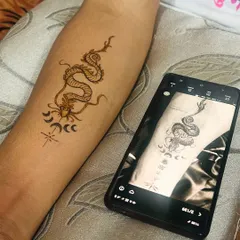 My dragon henna tattoo design next to the client's reference photo on their phone. I can recreate many modern designs you like.