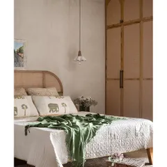 This master bedroom exudes a Wabi-Sabi charm with its limewash wall and cane-finished laminate wardrobe. The arched details on the wardrobe doors and the concrete pendant lights create a serene and earthy ambiance.