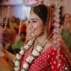 A candid shot of the bride during her ceremony. The updo remains perfectly in place, adorned with a garland, showcasing the durability and grace of the hairstyle.