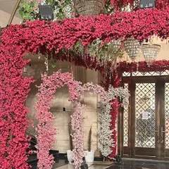 An opulent indoor entrance completely covered in vibrant pink cherry blossoms, creating a luxurious and immersive floral experience.