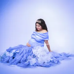 Feeling like royalty in a dreamy periwinkle blue gown. The soft tulle and off-shoulder design add a touch of romance, while the tiara completes this princess-inspired maternity look.