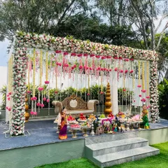For outdoor Seemantham ceremonies, I design open-air mandapams like this one. The structure is draped in dense floral arrangements and hanging garlands, creating a breathtaking stage amidst nature.