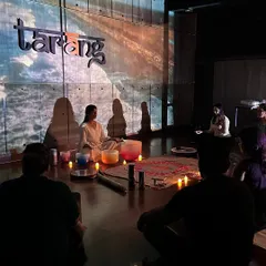 Some participants prefer to sit during meditation, and we encourage you to find whatever position is most comfortable. Here, the group is focused as the instructor plays the crystal bowls, with a serene ocean visual setting the mood.